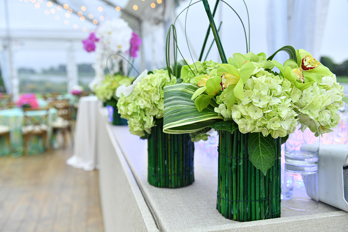 Elegant table centerpiece featuring green hydrangeas and cymbidium orchids at a formal event.